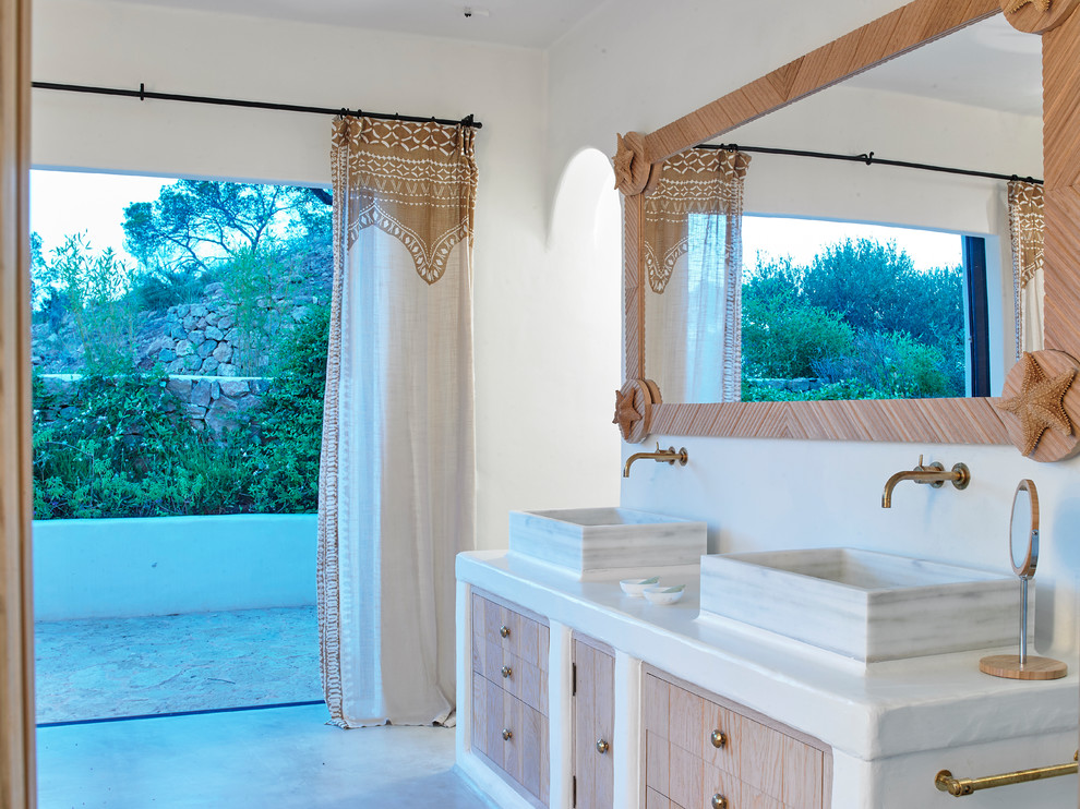 Idée de décoration pour une salle de bain ethnique en bois brun avec un placard à porte plane, un mur blanc, une vasque, un sol gris et un plan de toilette blanc.
