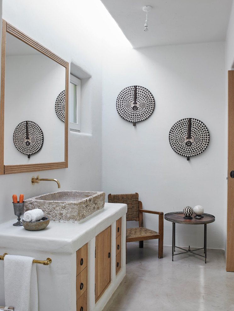 Immagine di una stanza da bagno tropicale con ante lisce, ante in legno scuro, pareti bianche, lavabo a bacinella, pavimento grigio e top bianco