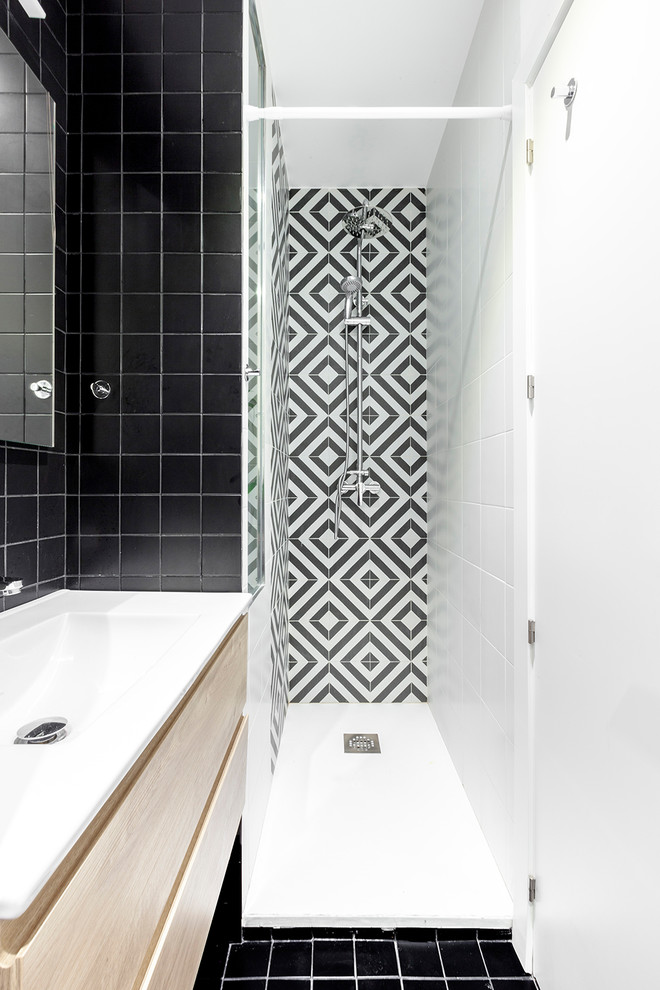 Idéer för att renovera ett litet nordiskt vit vitt badrum med dusch, med skåp i ljust trä, svart och vit kakel, ett integrerad handfat, svart golv, släta luckor, en dusch i en alkov och dusch med duschdraperi