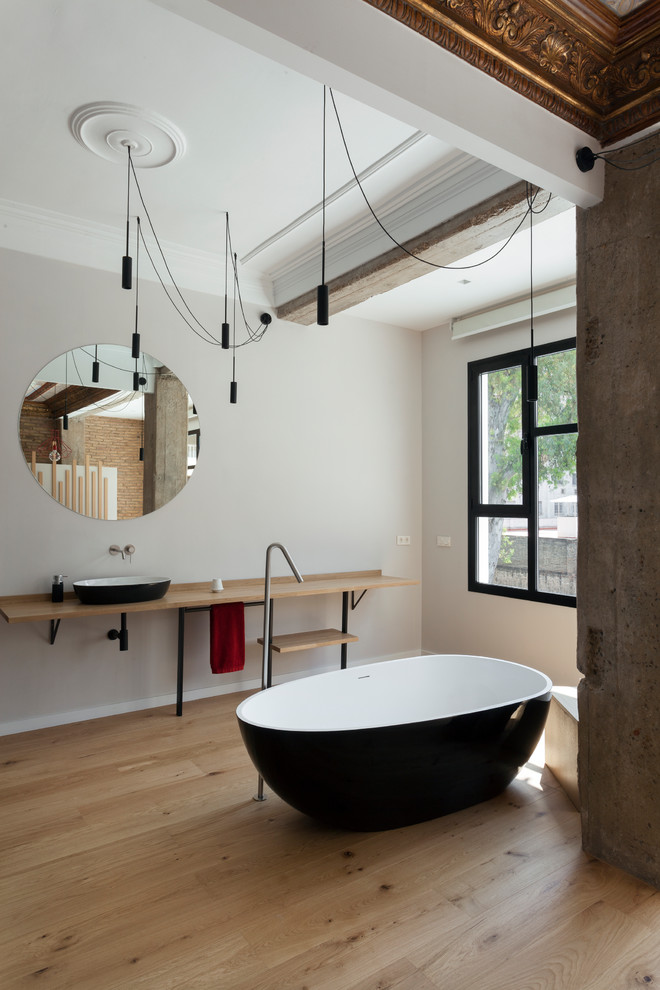 Foto de cuarto de baño principal contemporáneo grande con suelo de madera en tonos medios, bañera exenta, paredes grises, lavabo sobreencimera, encimera de madera, suelo beige y encimeras beige