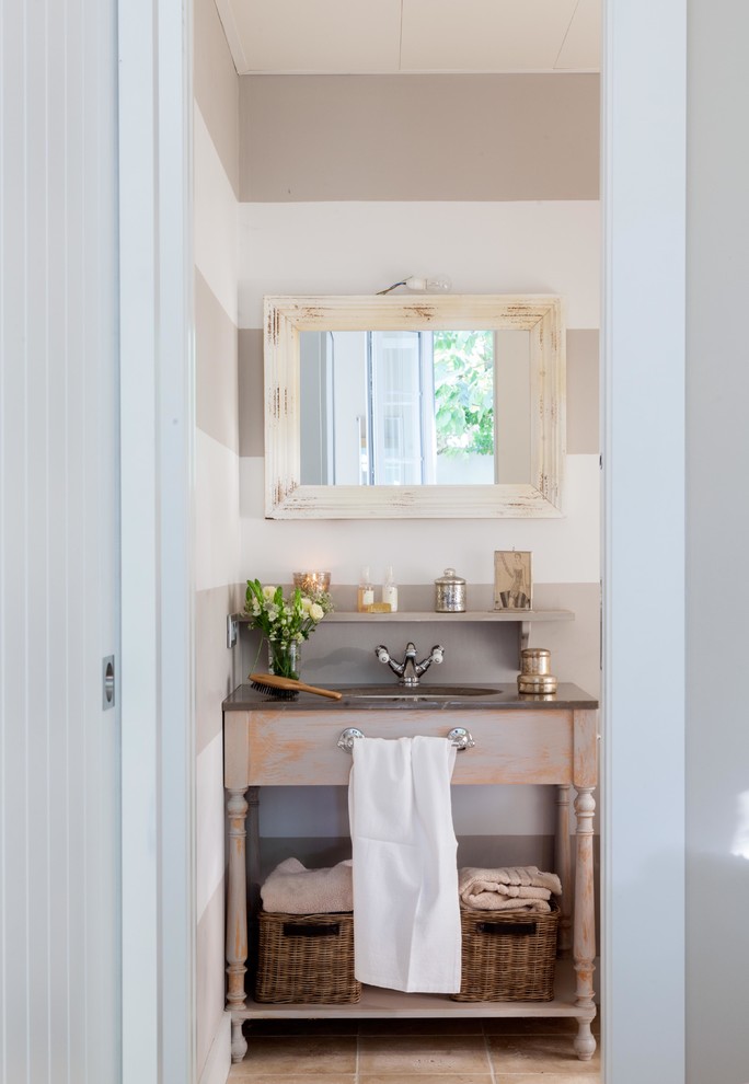 Cette image montre une salle de bain style shabby chic en bois vieilli avec un placard sans porte et un mur beige.