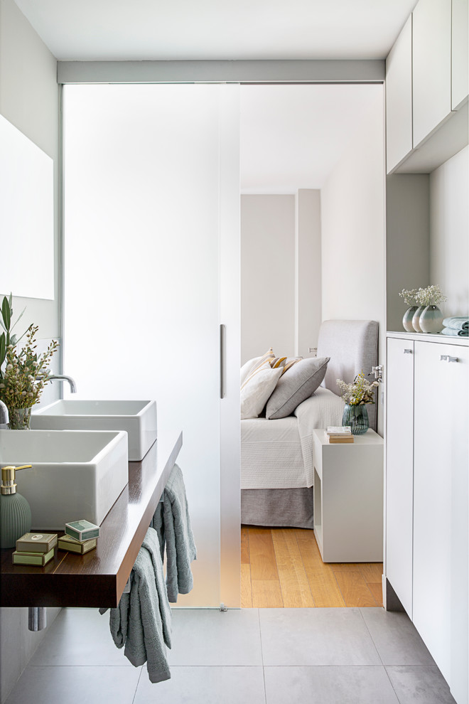 Идея дизайна: главная ванная комната в современном стиле с плоскими фасадами, белыми фасадами, серыми стенами, настольной раковиной, столешницей из дерева, серым полом и коричневой столешницей