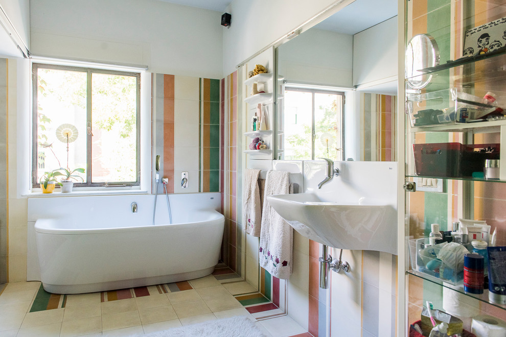 マドリードにある高級な中くらいなエクレクティックスタイルのおしゃれなマスターバスルーム (アルコーブ型浴槽、シャワー付き浴槽	、マルチカラーの壁、壁付け型シンク) の写真