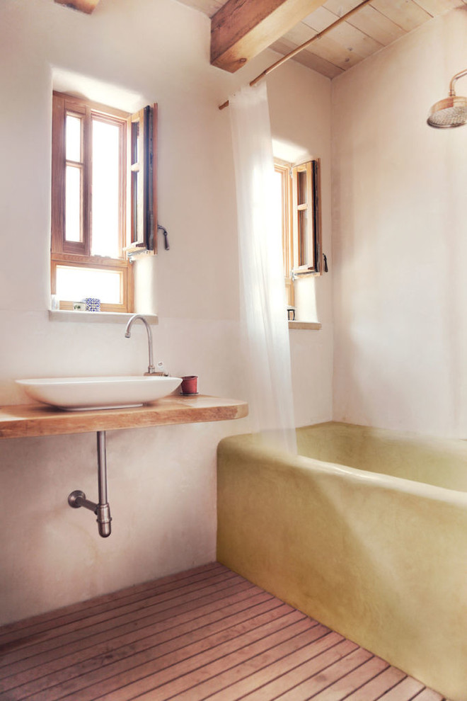 Bild på ett mellanstort lantligt brun brunt en-suite badrum, med vita väggar, bambugolv, ett fristående handfat, träbänkskiva, dusch med duschdraperi, öppna hyllor, skåp i mellenmörkt trä, ett platsbyggt badkar, en dusch/badkar-kombination och brunt golv