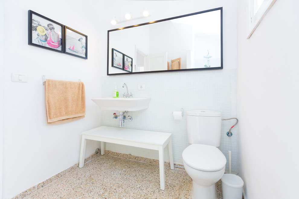 Imagen de cuarto de baño costero pequeño con lavabo suspendido, baldosas y/o azulejos blancos, baldosas y/o azulejos en mosaico, paredes blancas, sanitario de dos piezas y suelo de baldosas de cerámica
