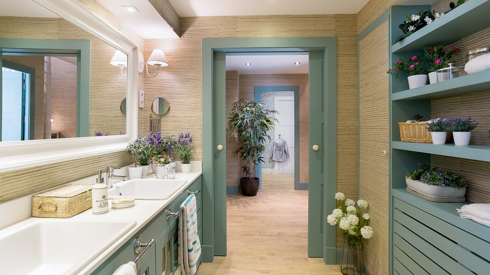 Modelo de cuarto de baño principal costero con puertas de armario verdes, paredes beige y lavabo encastrado
