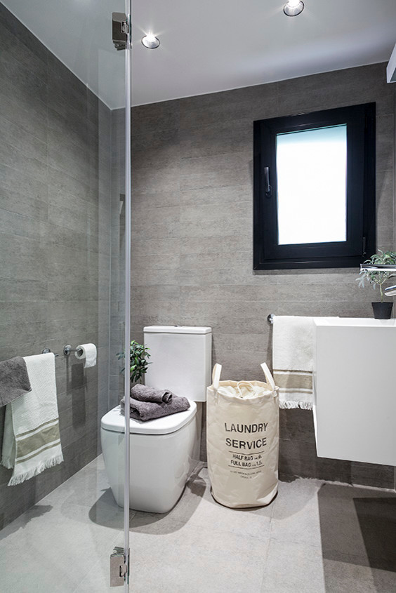 На фото: маленькая серо-белая ванная комната в скандинавском стиле с плоскими фасадами, белыми фасадами, душем без бортиков, раздельным унитазом, душевой кабиной и подвесной раковиной для на участке и в саду с