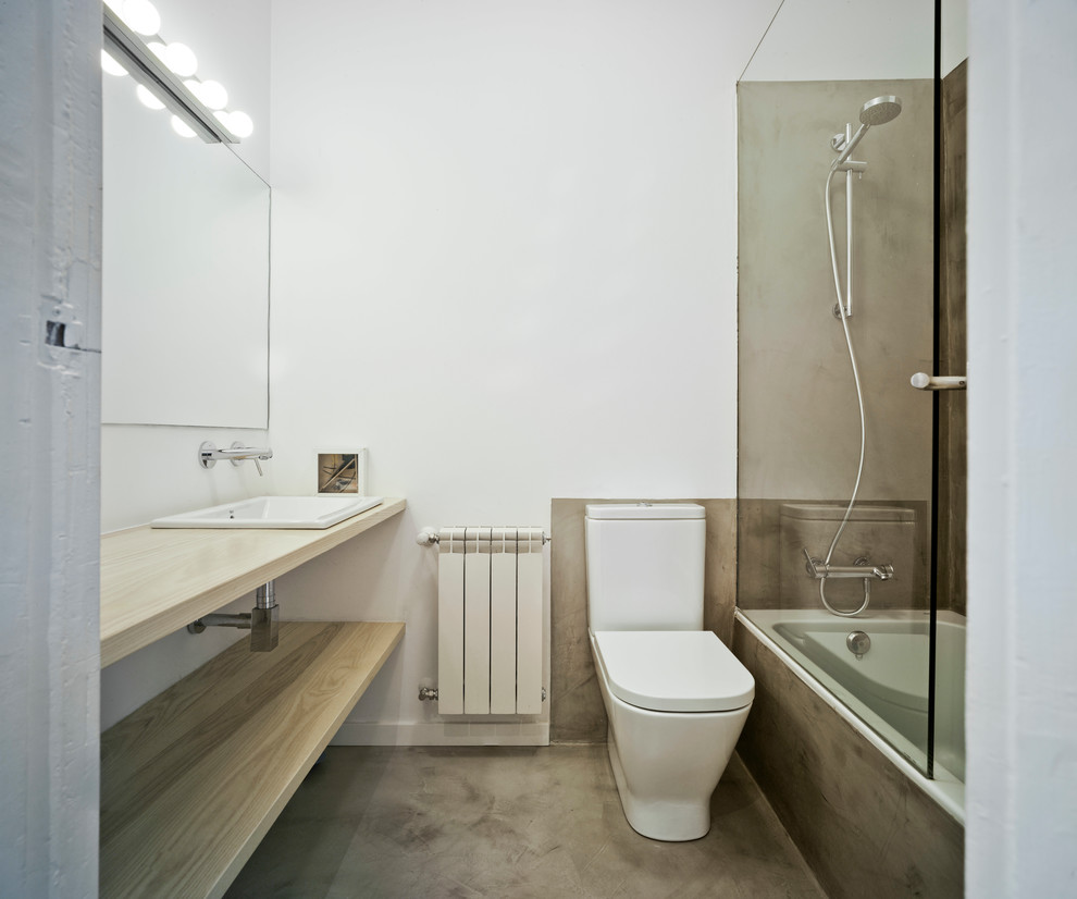 Стильный дизайн: главная ванная комната среднего размера в современном стиле с открытыми фасадами, светлыми деревянными фасадами, накладной ванной, душем над ванной, унитазом-моноблоком, белыми стенами, накладной раковиной, столешницей из дерева, бетонным полом и серым полом - последний тренд