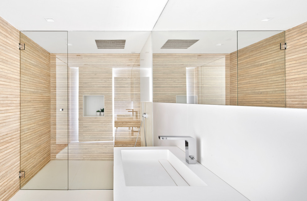 This is an example of a contemporary bathroom in Other with flat-panel cabinets, white cabinets, a built-in shower, a wall mounted toilet, white tiles, ceramic tiles, white walls, ceramic flooring, a wall-mounted sink, white floors and a hinged door.