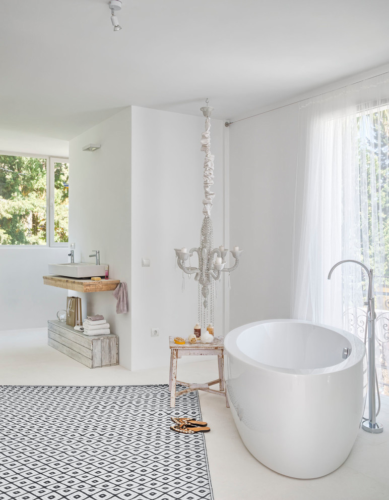 Inspiration for a large mediterranean ensuite bathroom in Other with a freestanding bath, a shower/bath combination, white walls, a vessel sink, wooden worktops and white floors.