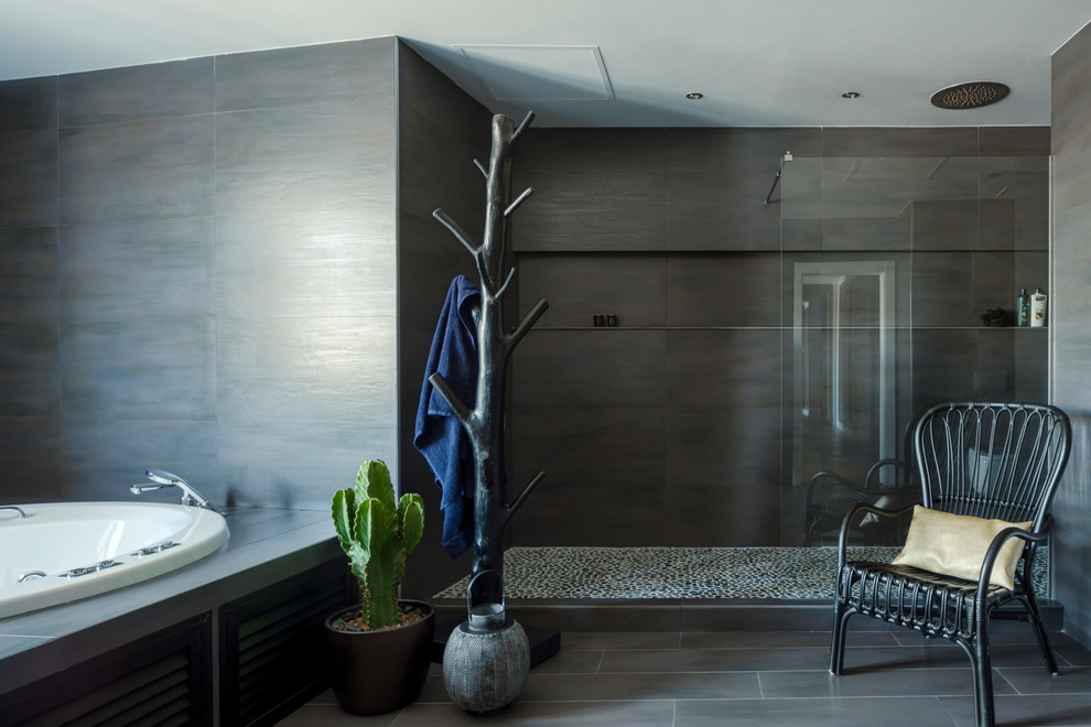 Bild på ett mycket stort funkis svart svart en-suite badrum, med möbel-liknande, svarta skåp, en jacuzzi, en kantlös dusch, svart kakel, keramikplattor, svarta väggar, klinkergolv i keramik, ett fristående handfat och grått golv