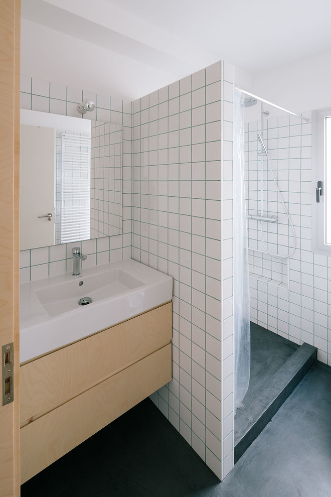 Ispirazione per una stanza da bagno con doccia scandinava di medie dimensioni con ante lisce, ante in legno chiaro, doccia alcova, pareti bianche e lavabo integrato