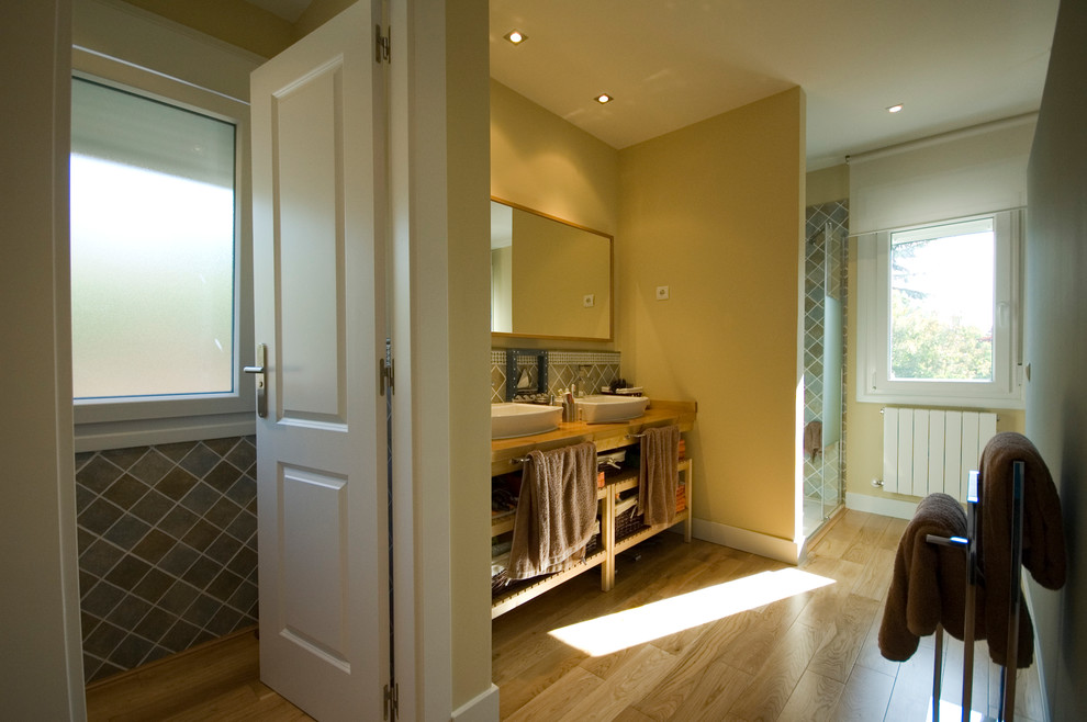Ejemplo de cuarto de baño tradicional de tamaño medio con paredes rosas, suelo de madera en tonos medios, aseo y ducha y lavabo sobreencimera