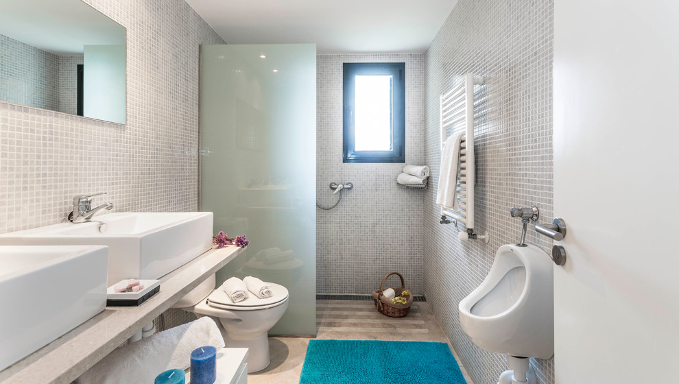 Medelhavsstil inredning av ett mellanstort badrum med dusch, med vita skåp, en kantlös dusch, ett urinoar, ett fristående handfat, marmorbänkskiva, vita väggar, öppna hyllor och med dusch som är öppen