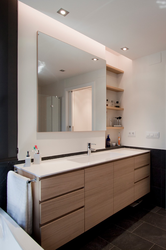 Foto de cuarto de baño principal contemporáneo de tamaño medio con armarios tipo mueble, puertas de armario de madera oscura, bañera empotrada, combinación de ducha y bañera, sanitario de una pieza, paredes blancas y lavabo integrado