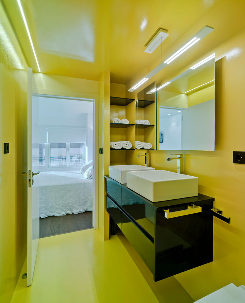 Ejemplo de cuarto de baño principal contemporáneo de tamaño medio con armarios con paneles lisos, puertas de armario negras, paredes amarillas y lavabo sobreencimera