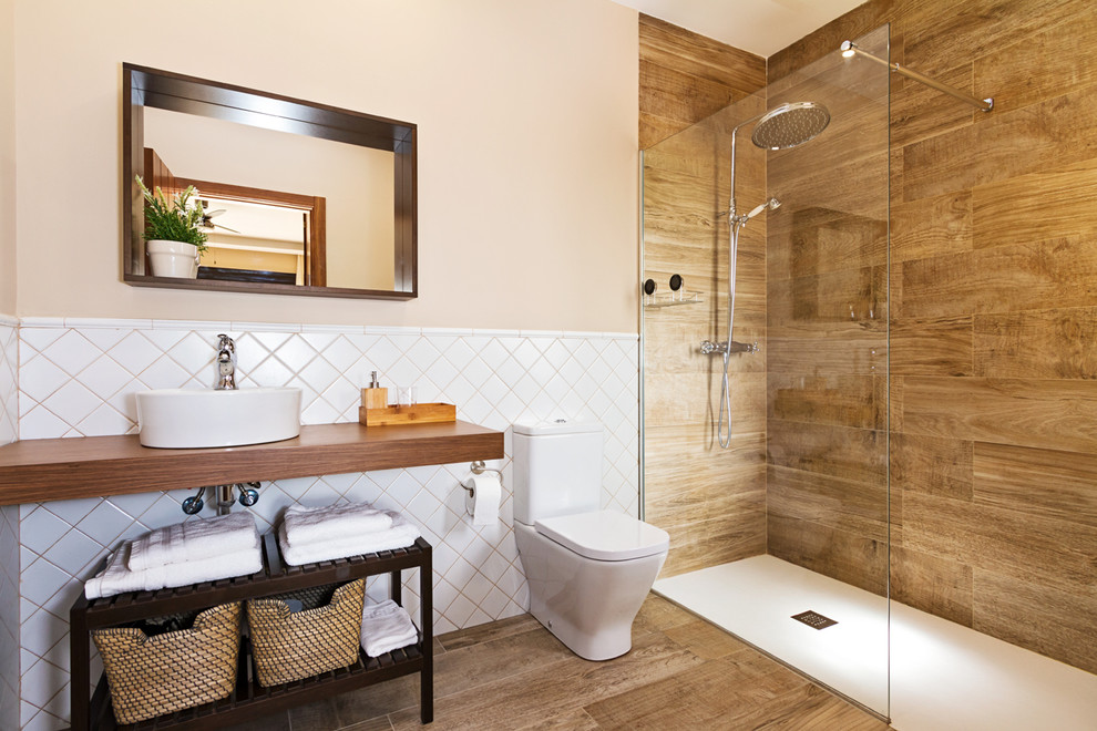 Inspiration för ett mellanstort rustikt badrum med dusch, med öppna hyllor, en kantlös dusch, en toalettstol med separat cisternkåpa, beige väggar, mellanmörkt trägolv, ett fristående handfat och träbänkskiva
