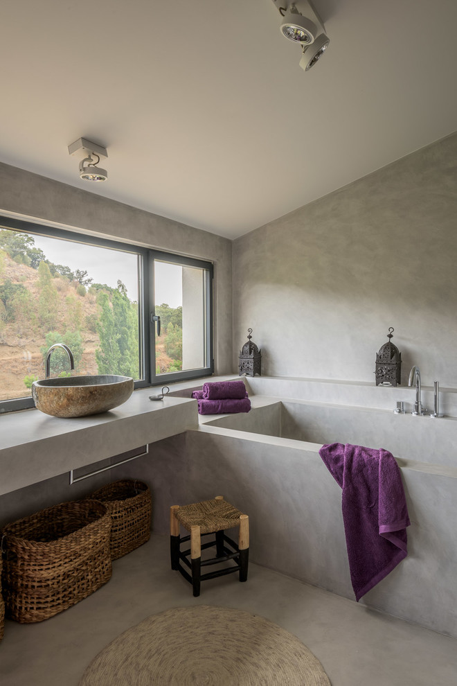 На фото: ванная комната в восточном стиле с ванной в нише и настольной раковиной
