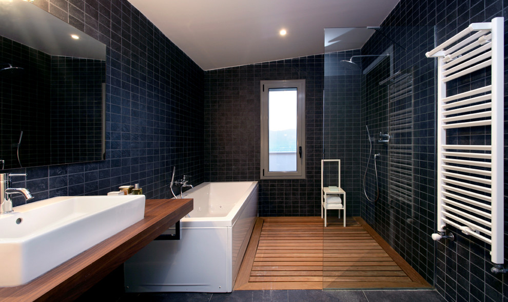 Modelo de cuarto de baño principal contemporáneo de tamaño medio con bañera encastrada, baldosas y/o azulejos de cerámica, paredes negras, suelo de madera en tonos medios, lavabo sobreencimera, encimera de madera y ducha a ras de suelo