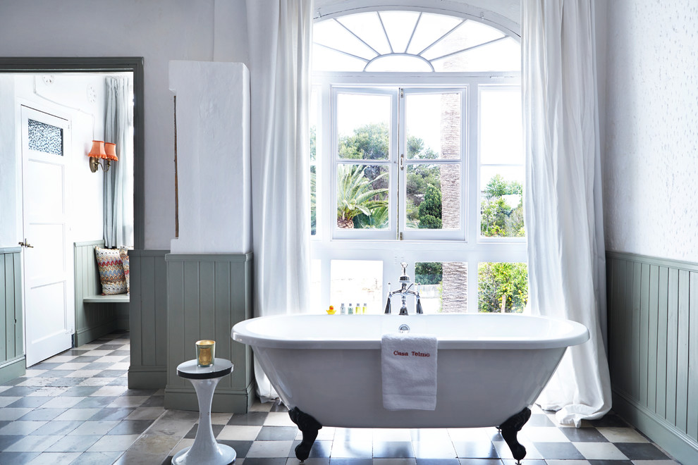 Foto di una stanza da bagno padronale mediterranea di medie dimensioni con vasca con piedi a zampa di leone, vasca/doccia, pareti bianche, pavimento con piastrelle in ceramica e pavimento multicolore