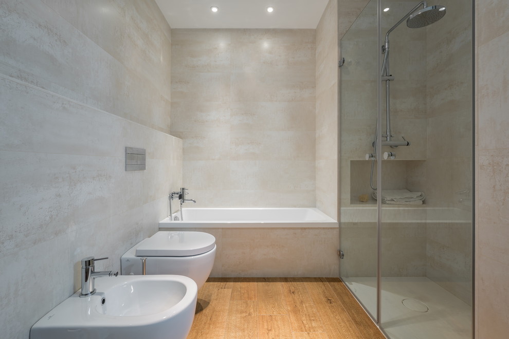 Пример оригинального дизайна: главная ванная комната среднего размера в современном стиле с ванной в нише, душем без бортиков, биде и паркетным полом среднего тона