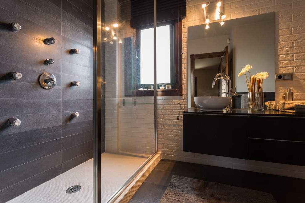 This is an example of a medium sized industrial shower room bathroom in Other with flat-panel cabinets, black cabinets, a walk-in shower, white walls and a vessel sink.