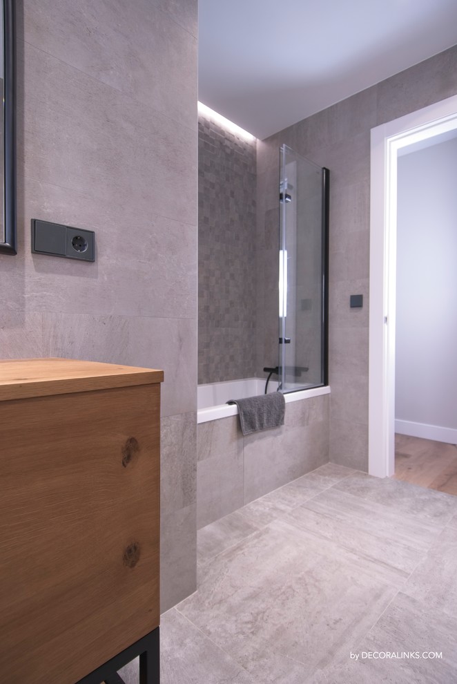 На фото: ванная комната в современном стиле с раздельным унитазом, серой плиткой и столешницей из дерева