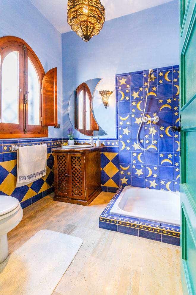 Foto de cuarto de baño mediterráneo con puertas de armario de madera oscura, ducha abierta, baldosas y/o azulejos azules, baldosas y/o azulejos amarillos, paredes azules, aseo y ducha, lavabo encastrado y ducha abierta