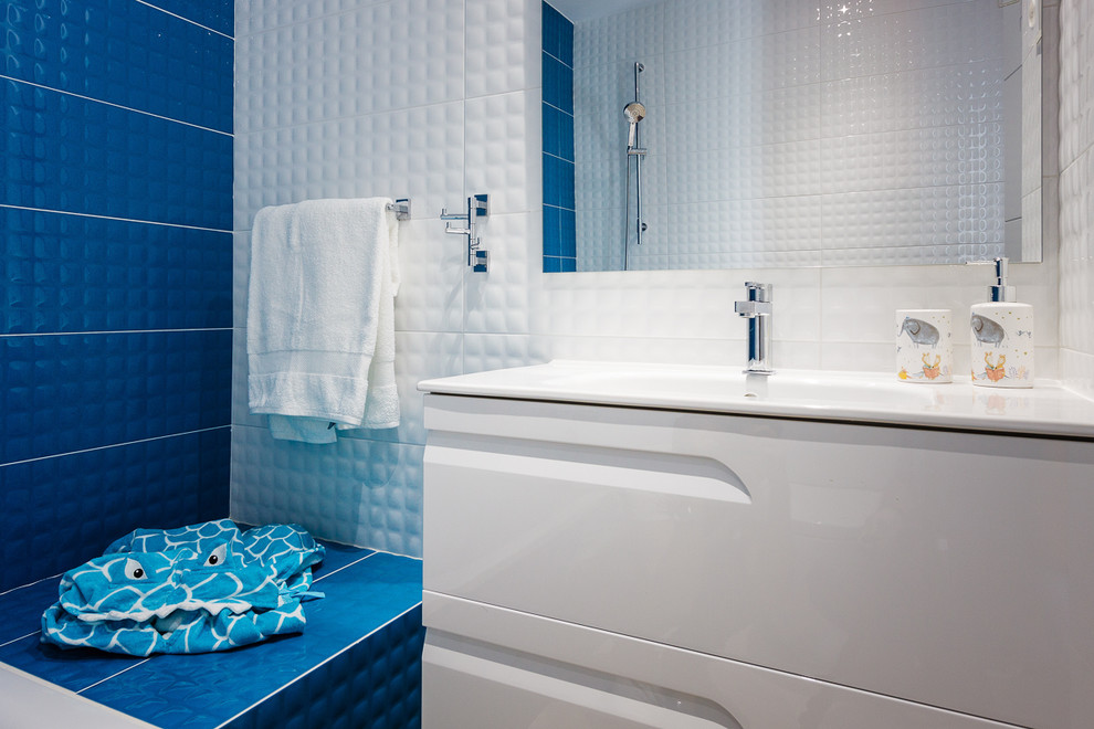 Inspiration pour une petite salle de bain minimaliste pour enfant avec un placard avec porte à panneau surélevé, des portes de placard blanches, une baignoire posée, un carrelage bleu, des carreaux de céramique, un mur bleu, un sol en ardoise, un lavabo posé et un sol beige.