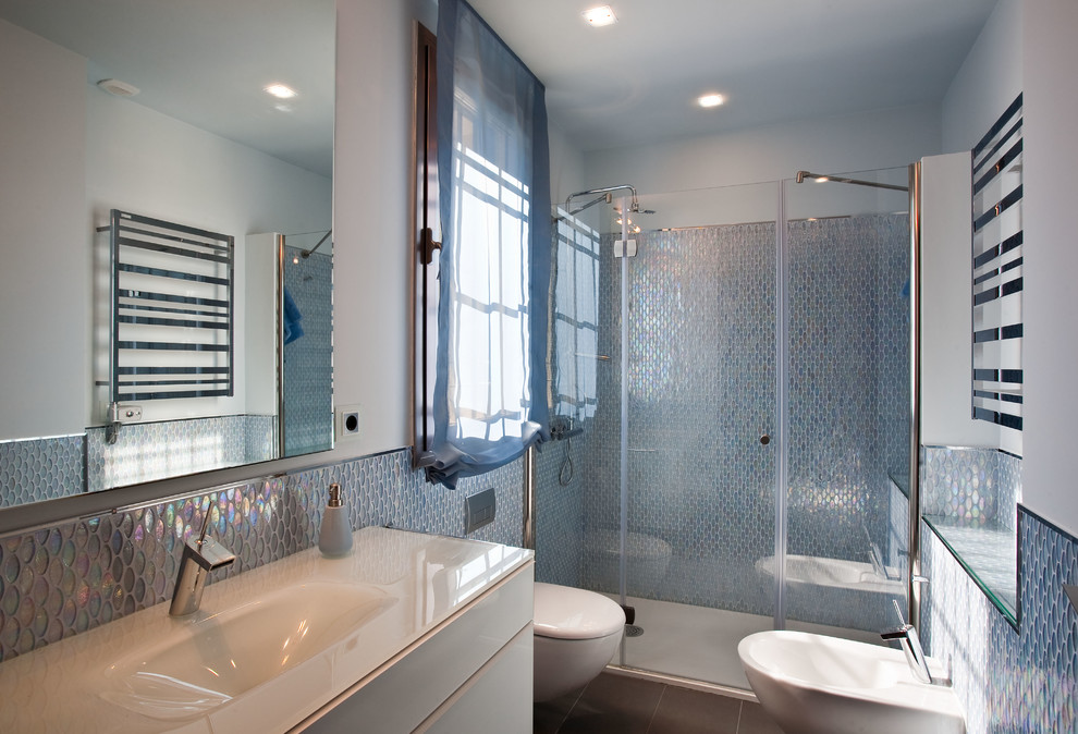 Design ideas for a contemporary shower room bathroom in Seville with flat-panel cabinets, white cabinets, an alcove shower, a wall mounted toilet, blue tiles, blue walls, a console sink, grey floors and a hinged door.