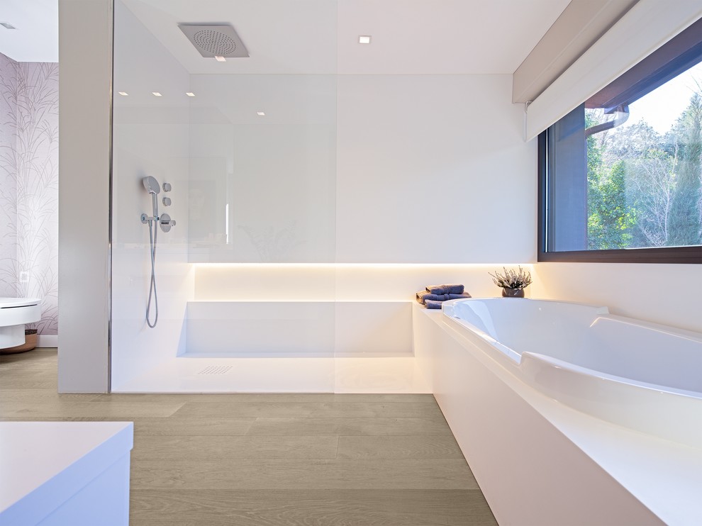 Cette image montre une grande salle de bain principale design avec une baignoire posée, une douche à l'italienne et un mur blanc.