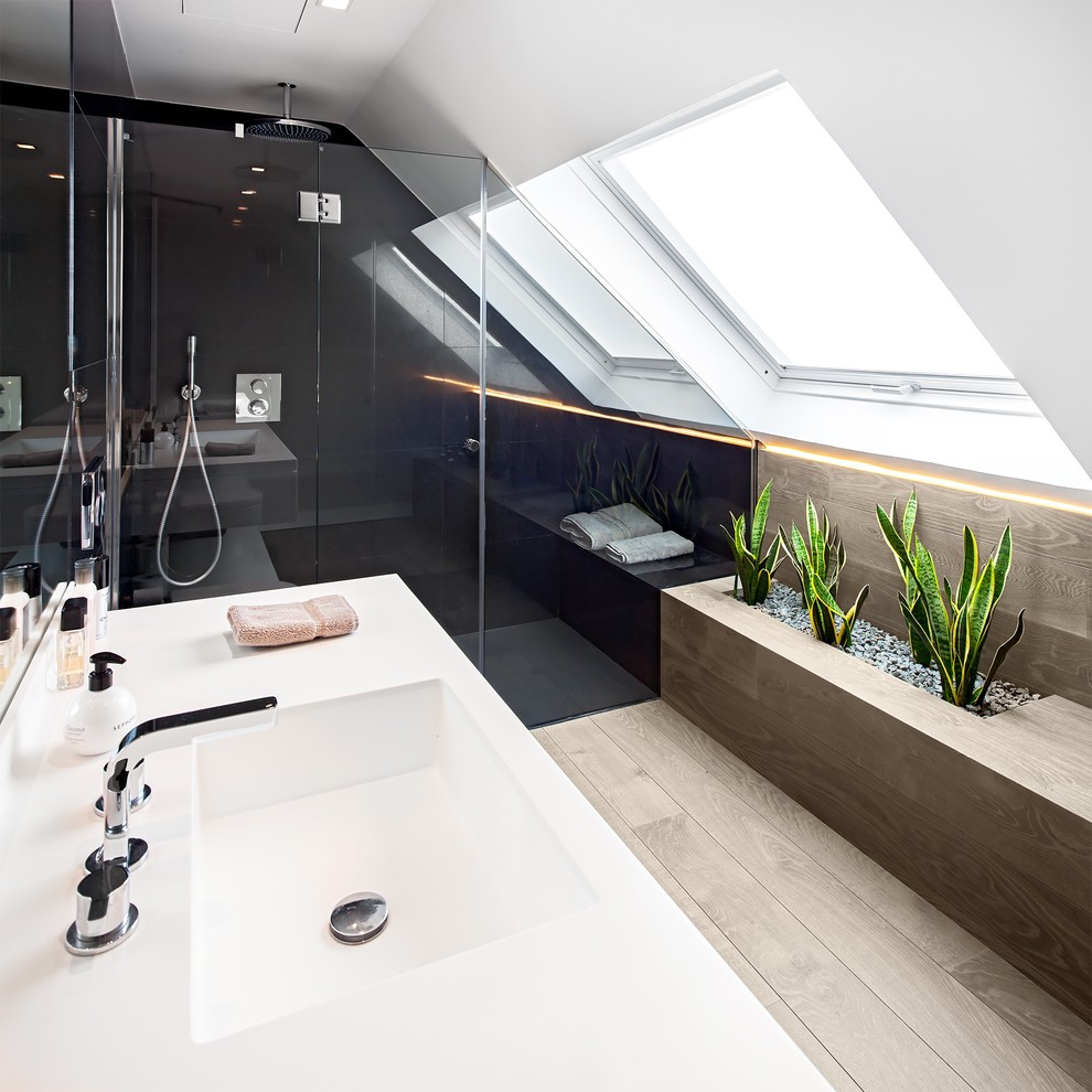 Foto på ett mellanstort funkis badrum med dusch, med en dusch i en alkov, flerfärgade väggar, ljust trägolv, ett integrerad handfat och bänkskiva i akrylsten