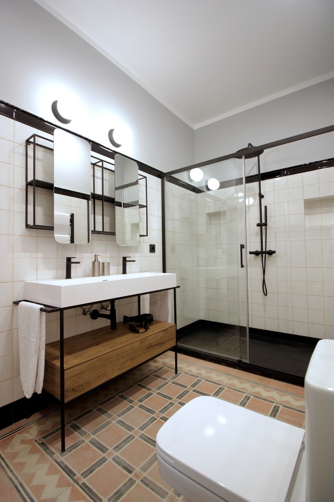 Klassisches Badezimmer mit offenen Schränken, hellbraunen Holzschränken, bodengleicher Dusche, integriertem Waschbecken, Schiebetür-Duschabtrennung, weißen Fliesen, grauer Wandfarbe und weißer Waschtischplatte in Madrid