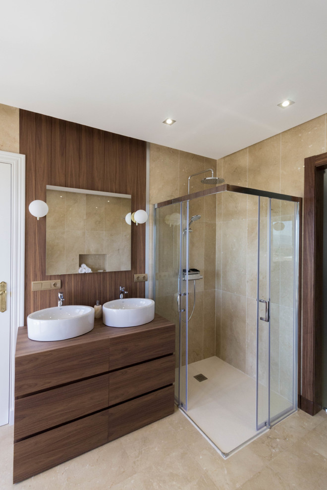 Cette photo montre une salle de bain tendance en bois foncé avec une douche d'angle, une vasque, un plan de toilette en bois, un placard à porte plane, un carrelage beige, un mur beige, un sol beige et une cabine de douche à porte coulissante.