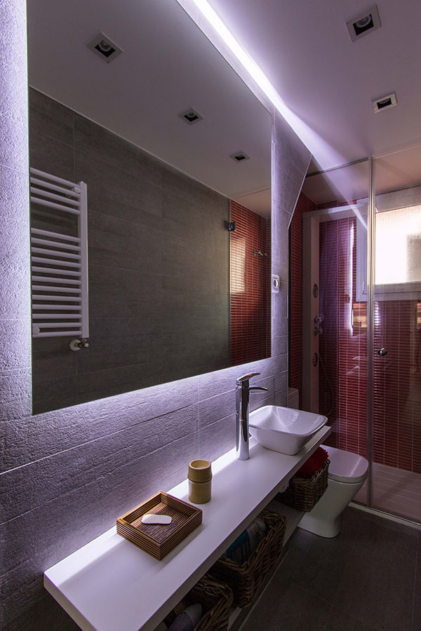 Cette image montre une salle d'eau design de taille moyenne avec un placard sans porte, une douche ouverte, WC suspendus et une vasque.