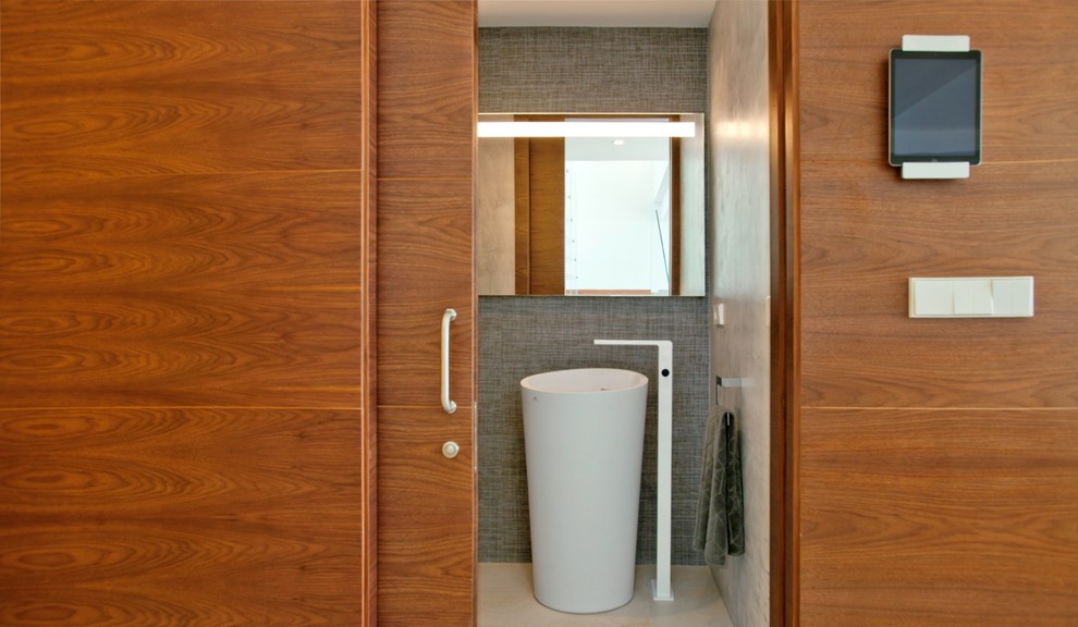 Small contemporary bathroom in Alicante-Costa Blanca with a pedestal sink, a wall mounted toilet, grey tiles, ceramic tiles, grey walls, ceramic flooring and beige floors.
