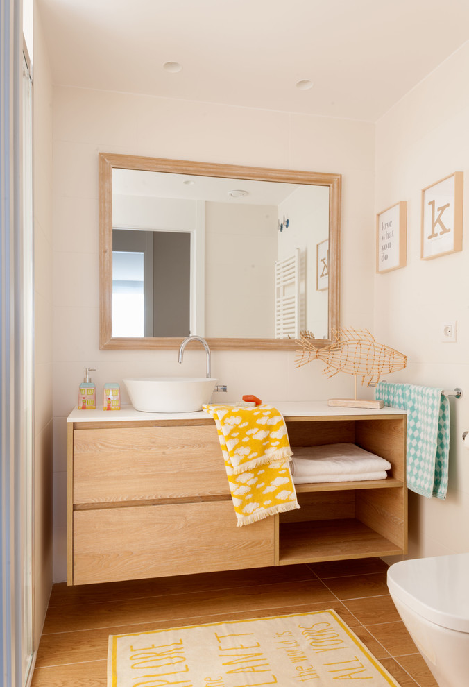 Foto di una stanza da bagno contemporanea con ante lisce, ante in legno scuro, pareti beige, lavabo a bacinella, pavimento marrone e top bianco