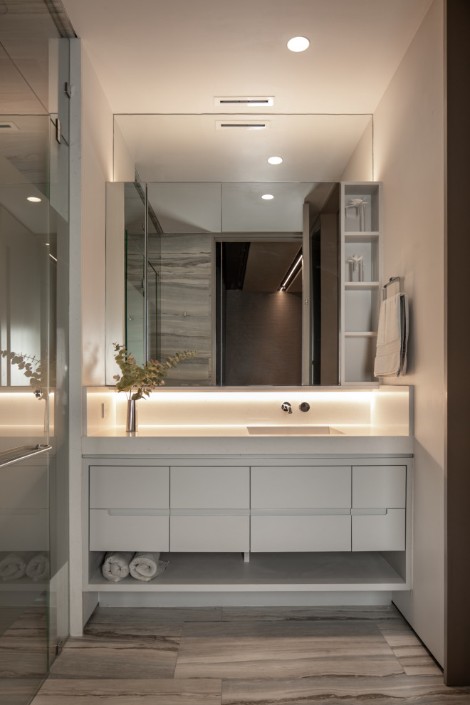 Exempel på ett modernt vit vitt badrum, med släta luckor, grå skåp, grå väggar, ett integrerad handfat och grått golv