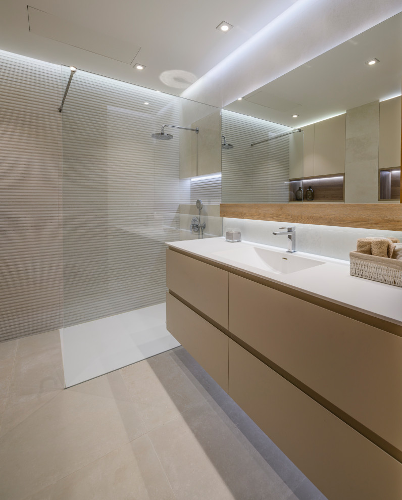 Small contemporary ensuite bathroom in Other with freestanding cabinets, beige cabinets, a built-in shower, a wall mounted toilet, beige tiles, ceramic tiles, beige walls, ceramic flooring, a trough sink, engineered stone worktops, beige floors, an open shower and white worktops.