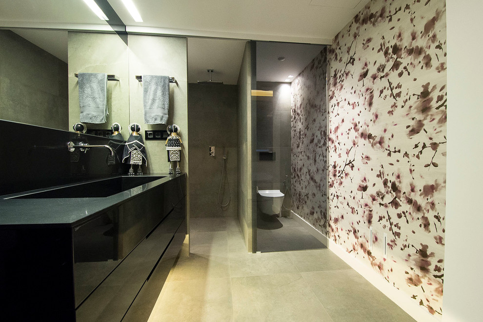 Modern inredning av ett mellanstort badrum med dusch, med släta luckor, svarta skåp, en kantlös dusch, en vägghängd toalettstol, flerfärgade väggar, klinkergolv i keramik och ett integrerad handfat