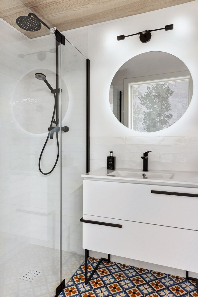 Idéer för små minimalistiska vitt badrum med dusch, med möbel-liknande, vita skåp, en kantlös dusch, en toalettstol med hel cisternkåpa, vit kakel, keramikplattor, vita väggar, klinkergolv i keramik, ett integrerad handfat, bänkskiva i kvarts, blått golv och dusch med gångjärnsdörr