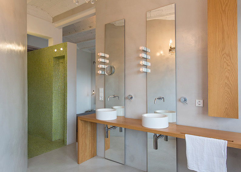 На фото: главная ванная комната среднего размера в современном стиле с открытыми фасадами, отдельно стоящей ванной, серой плиткой, белыми стенами, бетонным полом, настольной раковиной, столешницей из дерева и серым полом с