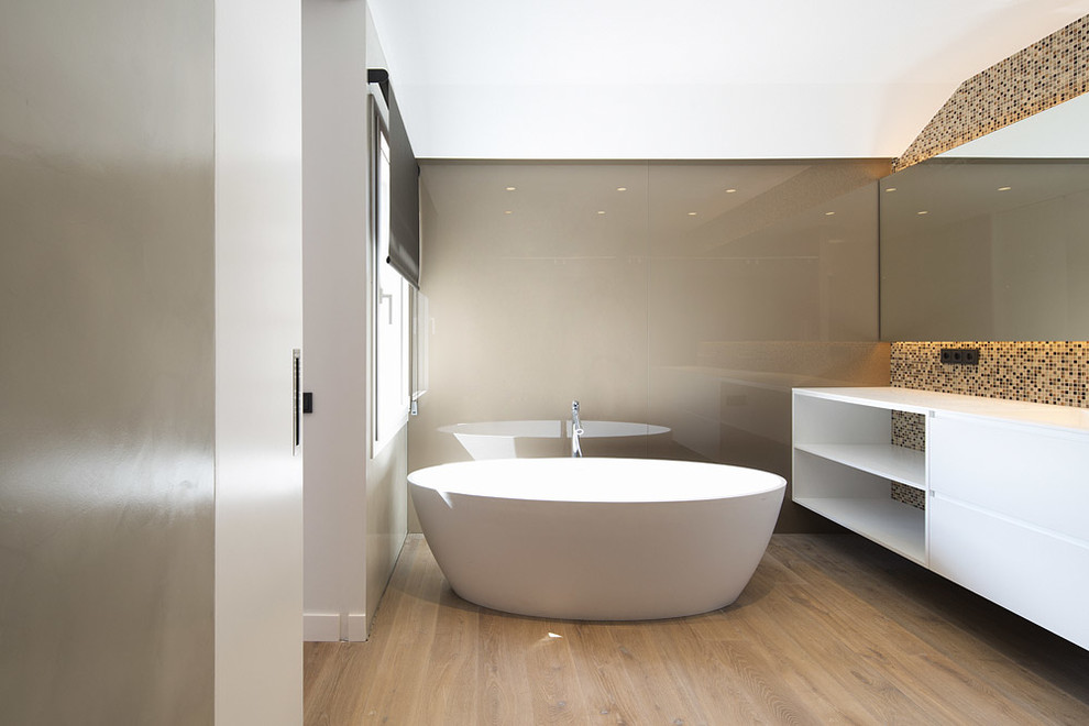 Diseño de cuarto de baño principal grande con bañera exenta, baldosas y/o azulejos multicolor, paredes beige, suelo de madera en tonos medios y suelo marrón