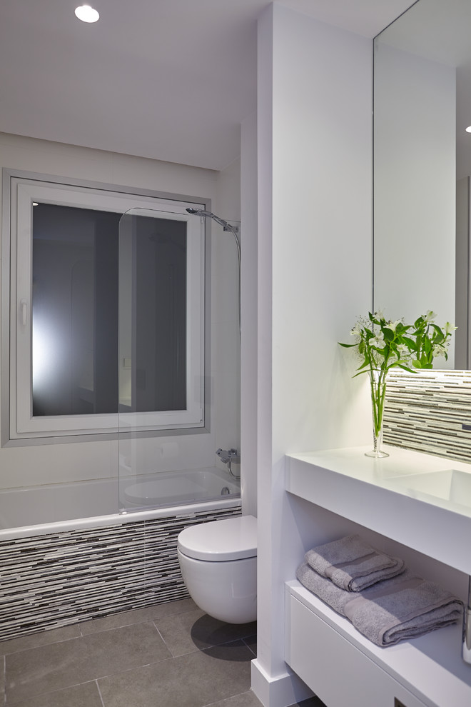 Photo of a medium sized contemporary bathroom in Other with open cabinets, white cabinets, a wall mounted toilet, white walls, ceramic flooring and an integrated sink.