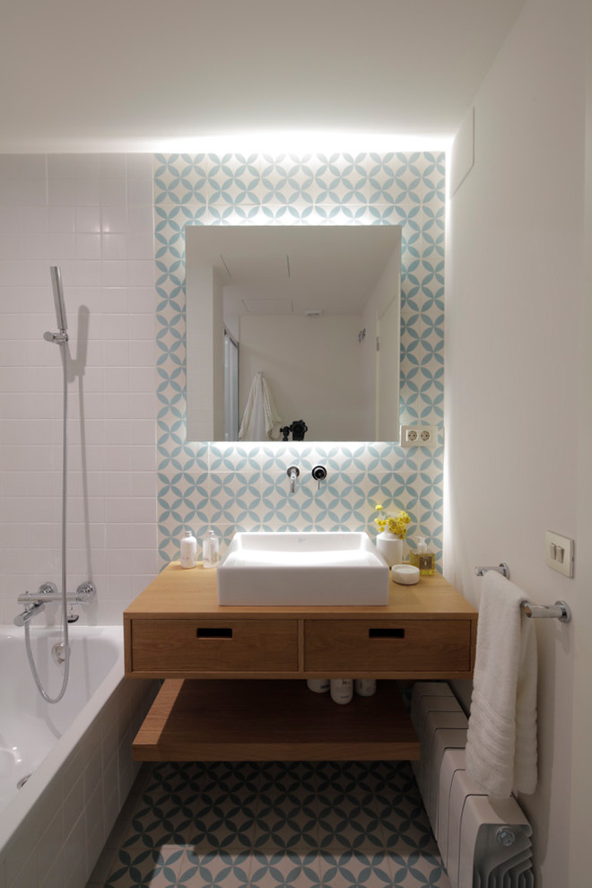 Small eclectic 3/4 blue tile, white tile and ceramic tile ceramic tile and multicolored floor bathroom photo in Barcelona with white walls, a vessel sink, wood countertops, flat-panel cabinets and medium tone wood cabinets