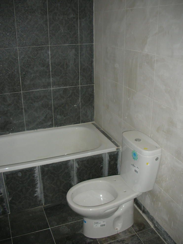 Modern inredning av ett litet en-suite badrum, med vita skåp, ett badkar i en alkov, en bidé, svart kakel, keramikplattor, svarta väggar, klinkergolv i keramik, ett piedestal handfat och svart golv
