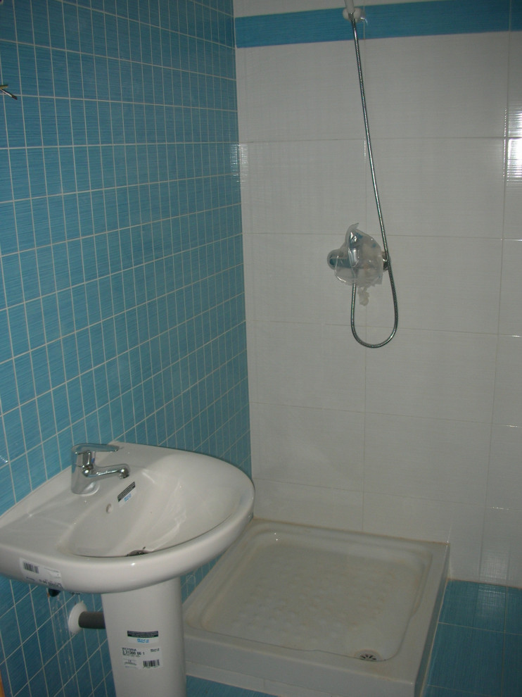 Bild på ett litet funkis badrum med dusch, med vita skåp, en hörndusch, en bidé, blå kakel, keramikplattor, gröna väggar, klinkergolv i keramik, ett piedestal handfat och blått golv