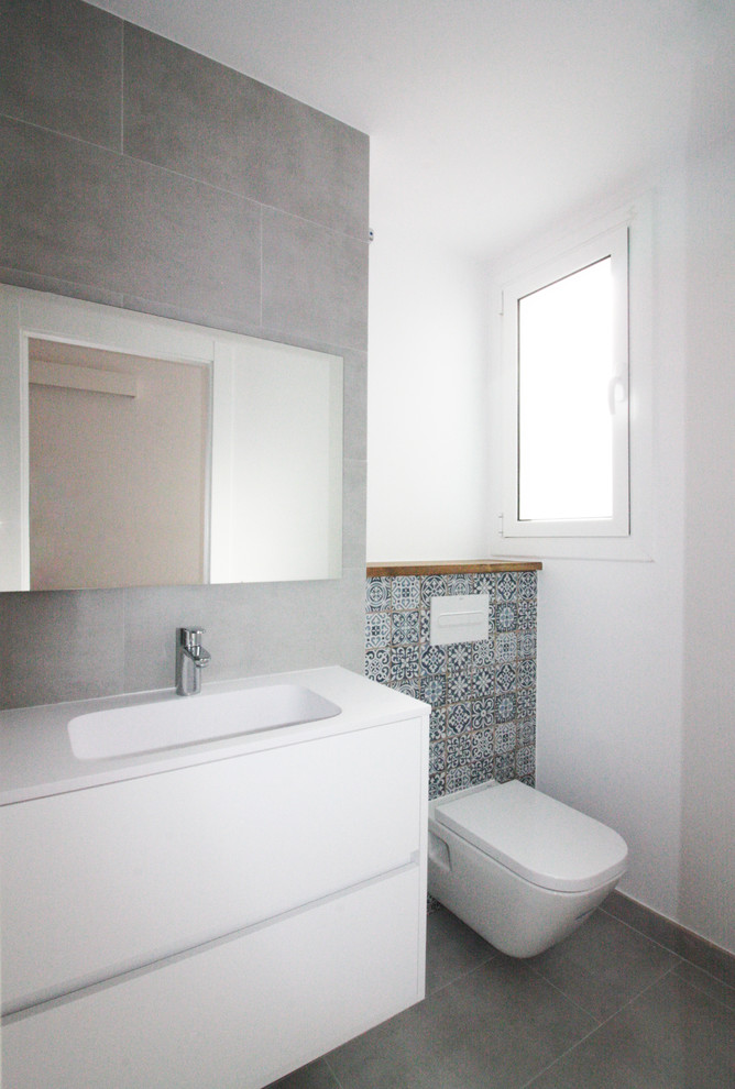 Cette image montre une petite salle de bain minimaliste avec une douche ouverte et WC suspendus.