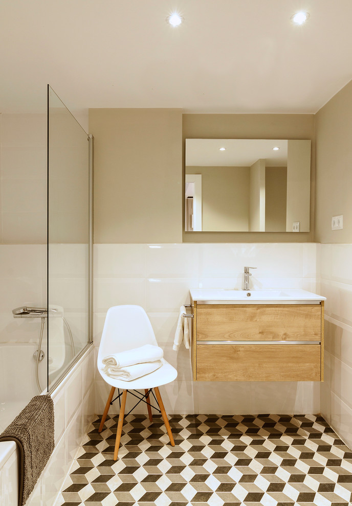 Inspiration för mellanstora skandinaviska en-suite badrum, med släta luckor, skåp i mellenmörkt trä, ett badkar i en alkov, en dusch/badkar-kombination, beige väggar, ett väggmonterat handfat, vit kakel och med dusch som är öppen