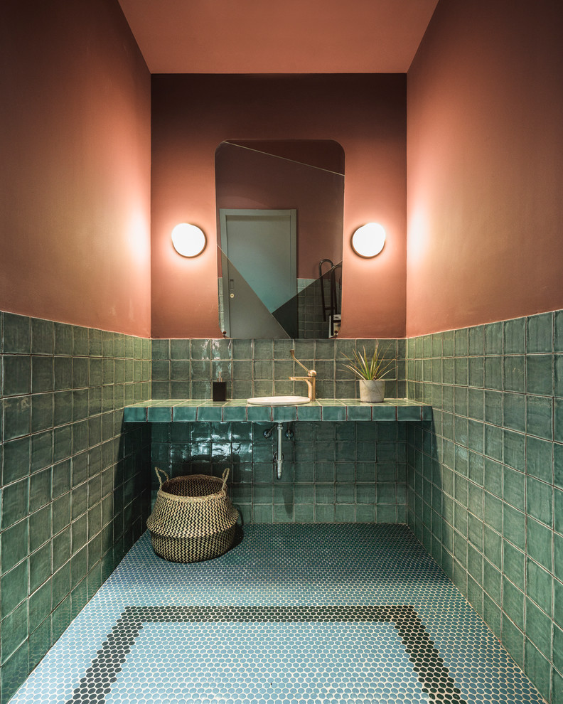 Réalisation d'une salle de bain principale ethnique de taille moyenne avec un placard sans porte, des portes de placards vertess, un carrelage vert, mosaïque, un mur orange, un sol en carrelage de terre cuite, un plan de toilette en carrelage, un sol vert et un plan de toilette vert.
